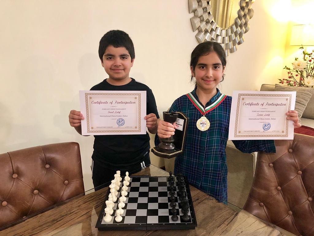 Young chess students celebrating a tournament victory and improved chess rating at Brainiac Chess Academy