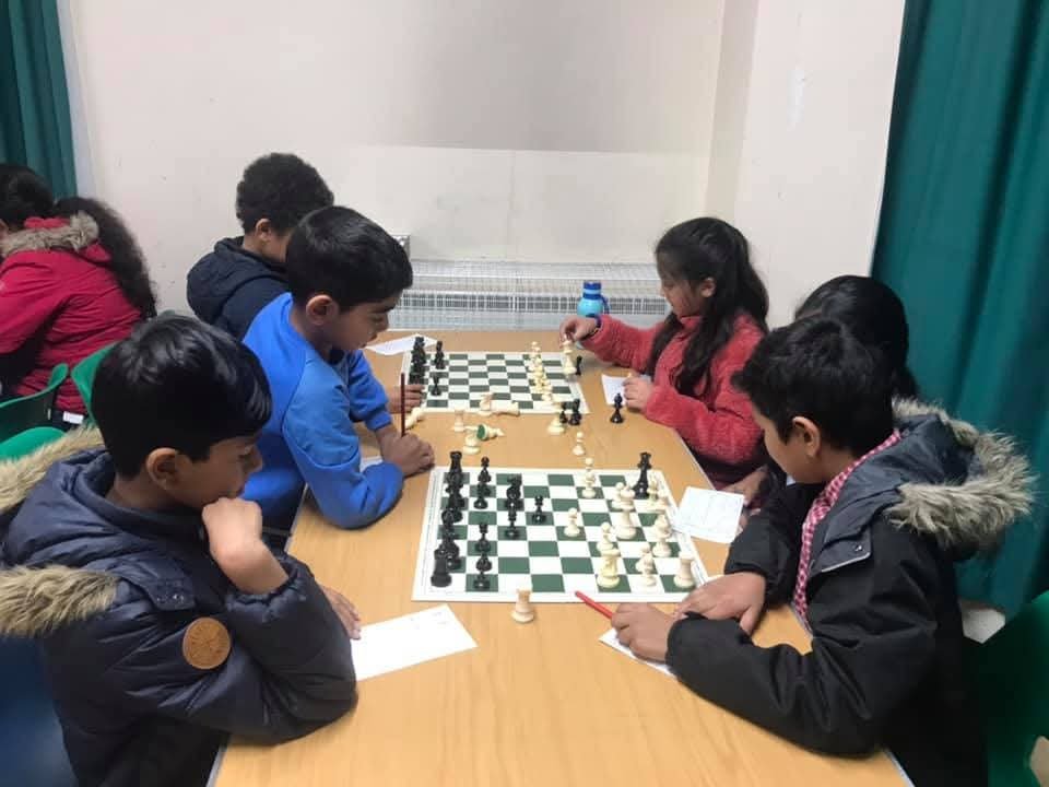 A well-prepared chess player confidently making a move during a competitive tournament round