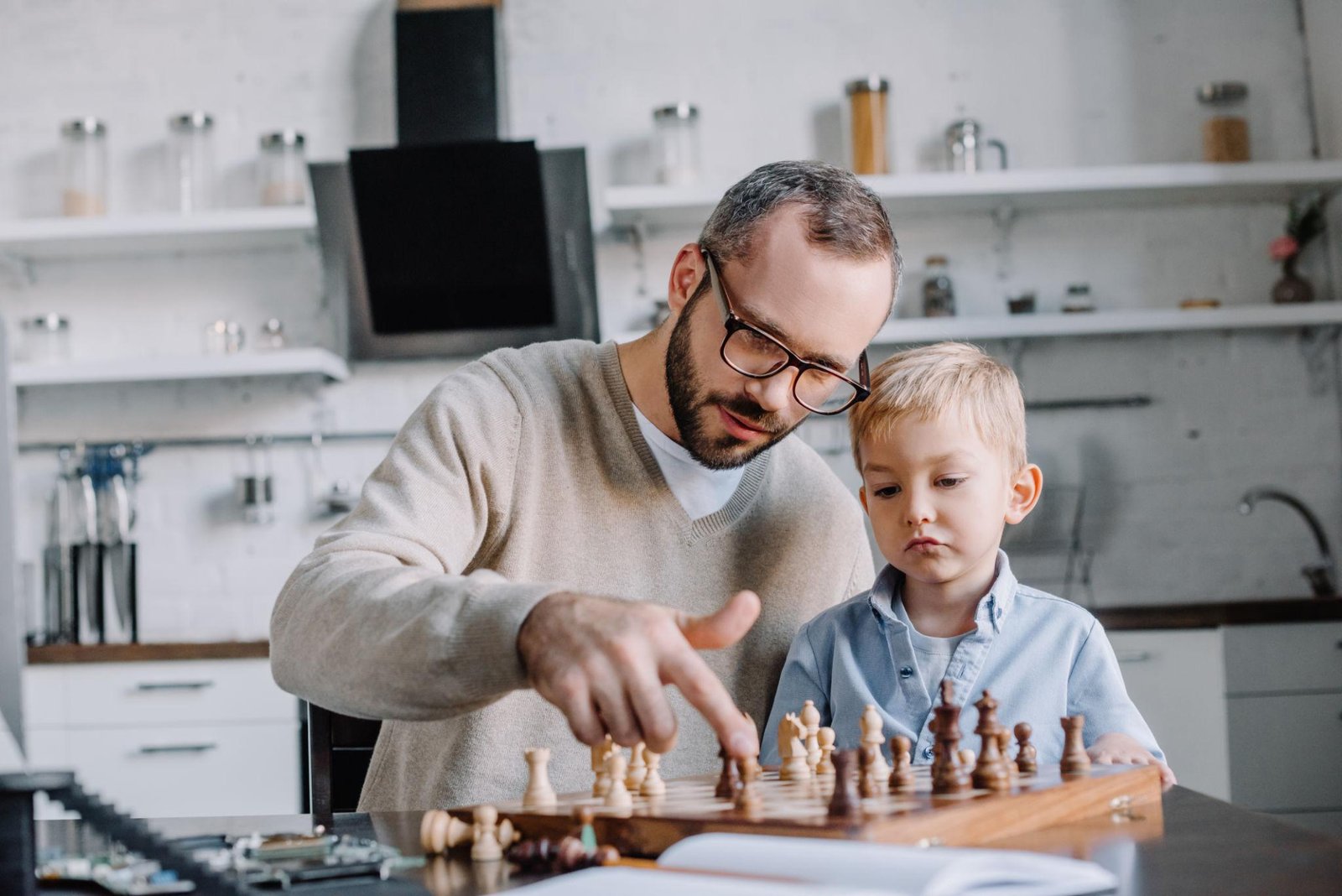 Parent teaching a child chess moves at home
