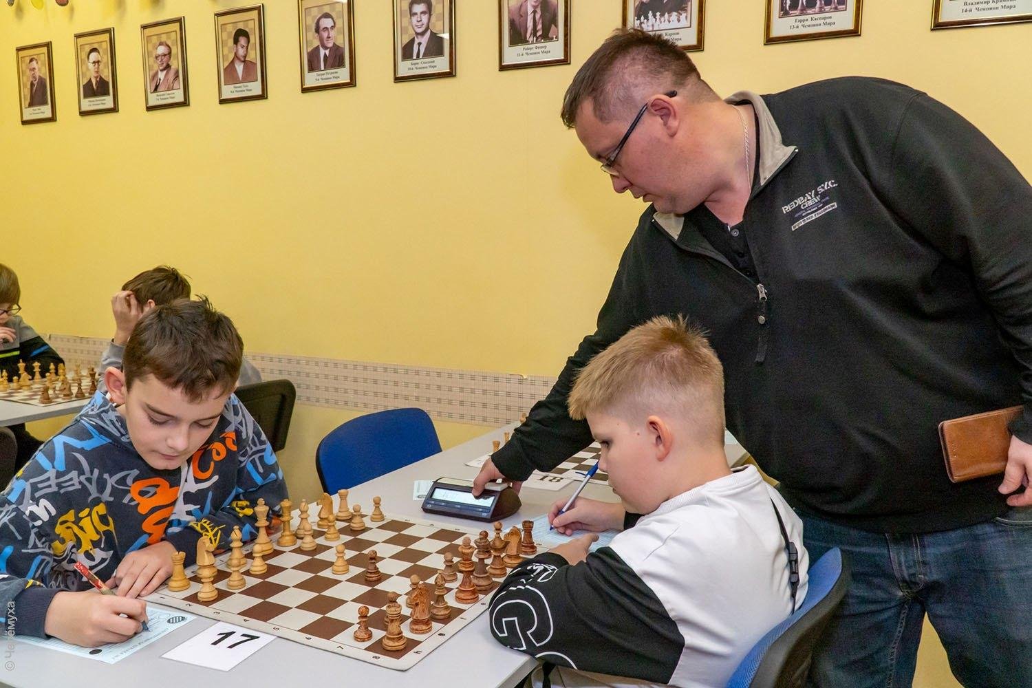 Professional chess coach guiding a young tournament player