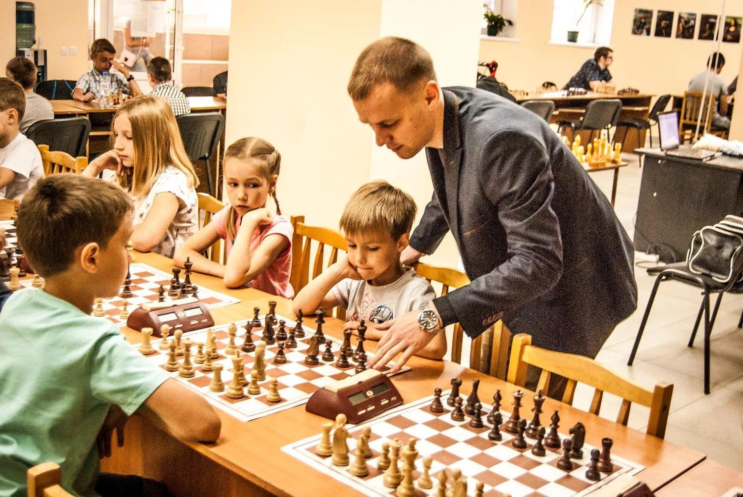 Professional coach conducting kids chess training at an academy