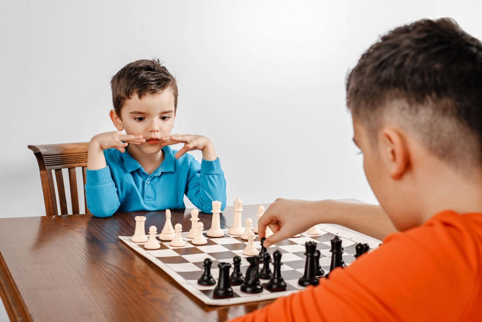 Child analyzing a chessboard to improve problem-solving skills