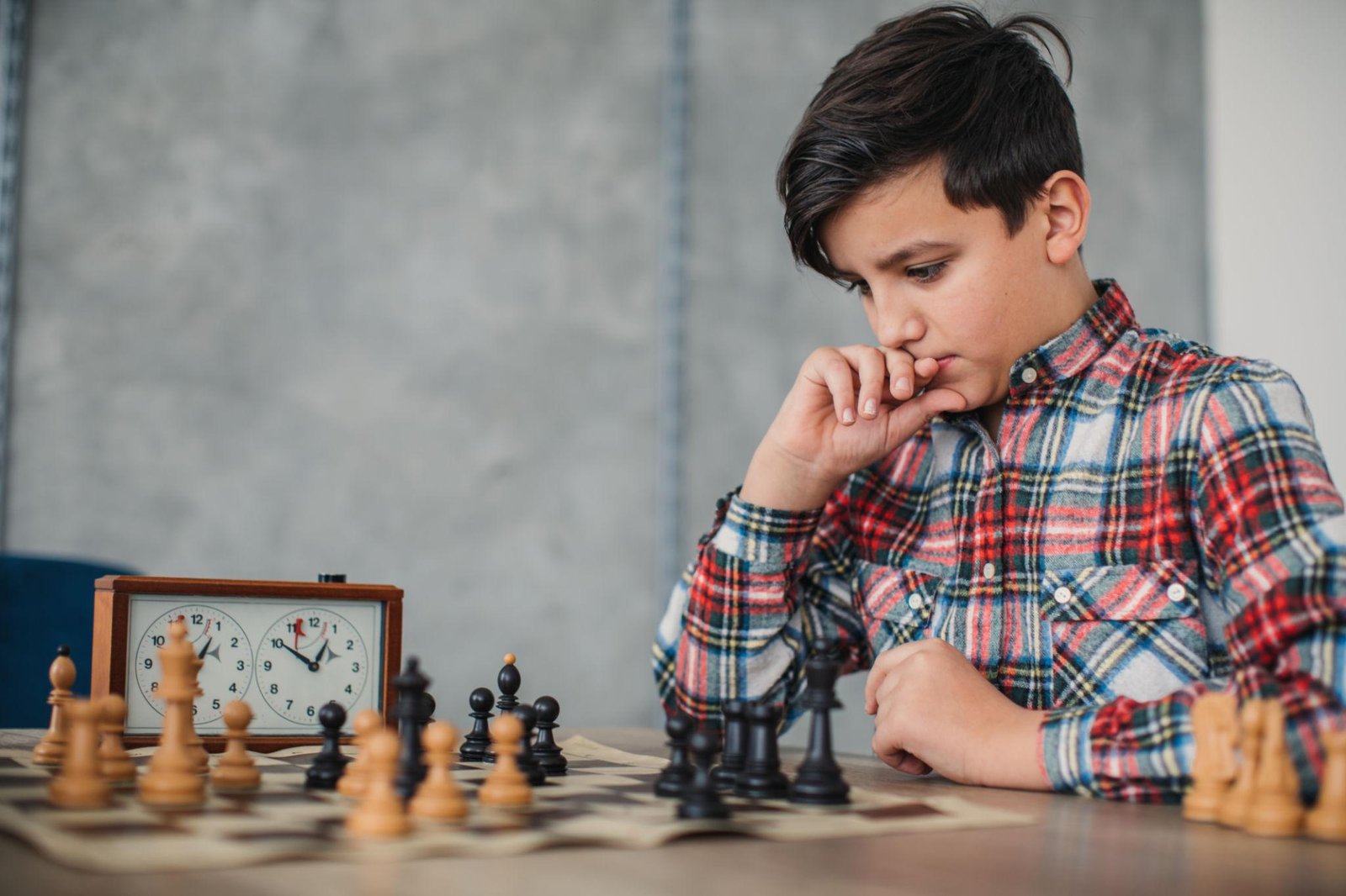 Child solving a chess puzzle with focus